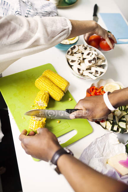 Manos cortar verduras en la cocina - foto de stock