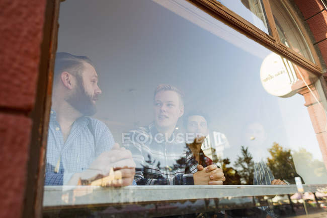 Hombres comunicándose en la cafetería - foto de stock
