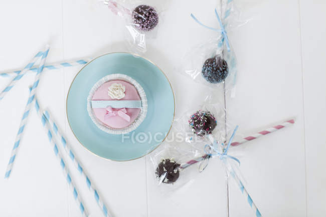 Cupcake et pops sur table blanche — Photo de stock