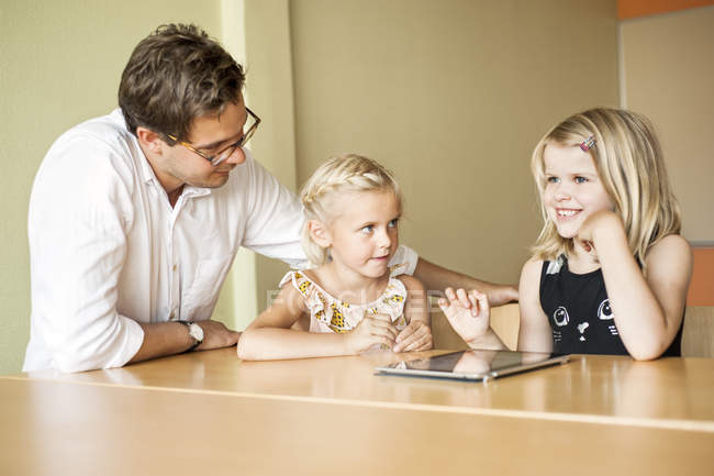 Teacher with girls using tablet computer — Stock Photo
