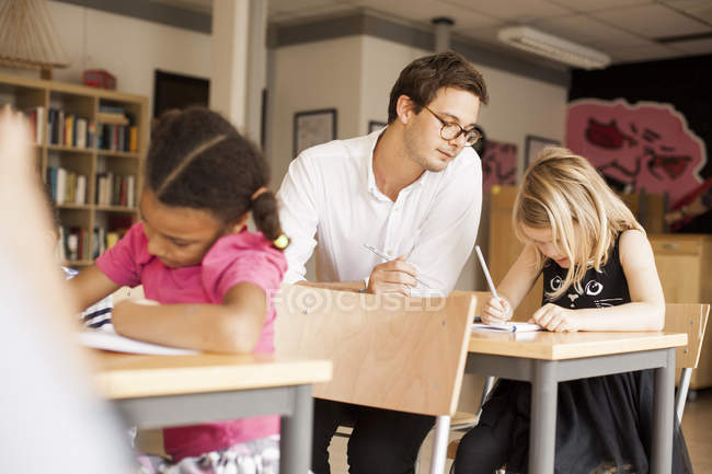 Male teacher teaching girl — Stock Photo