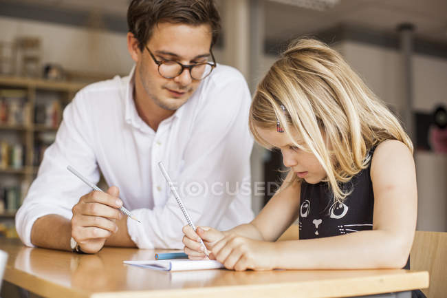 Profesor masculino enseñando chica - foto de stock