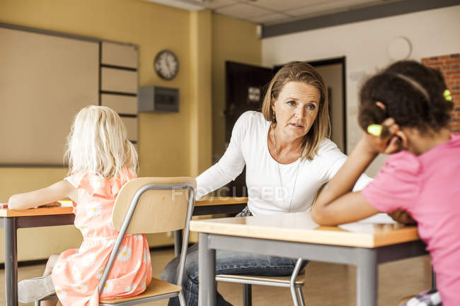 Зрілий вчитель розмовляє з дівчиною — стокове фото