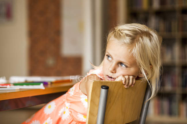 Menina na cadeira em sala de aula — Fotografia de Stock