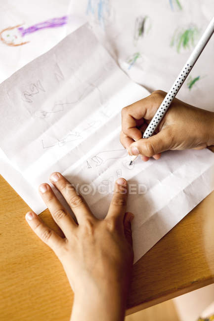 Schulmädchen kritzelt auf Papier — Stockfoto