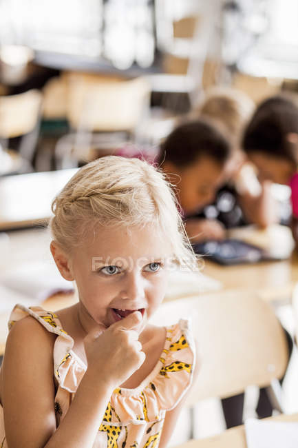 Fille réfléchie dans la salle de classe — Photo de stock