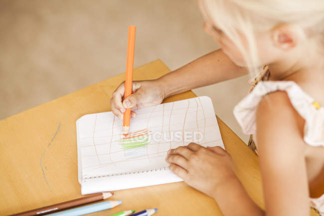 Girl drawing with colored pencils — Stock Photo