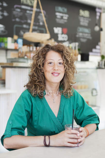 Frau sitzt am Café-Tisch — Stockfoto