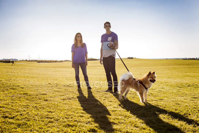 Couple with dog standing — Stock Photo