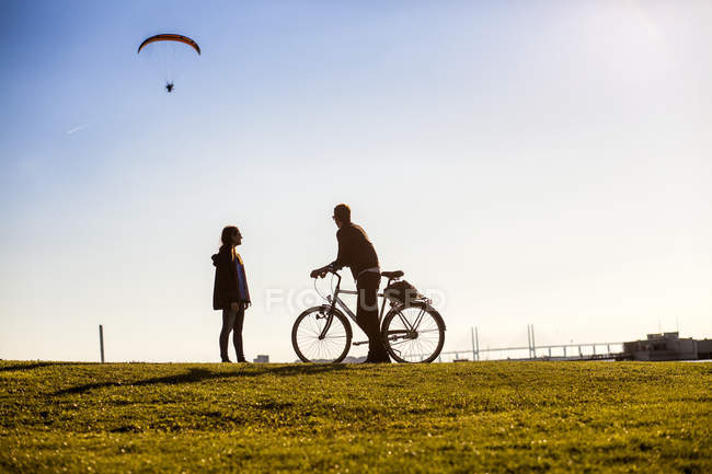 Couple watching paraglider — Stock Photo