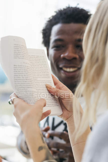Studente universitario lettura libro per amico — Foto stock