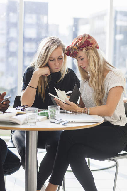 Female friends reading notes — Stock Photo
