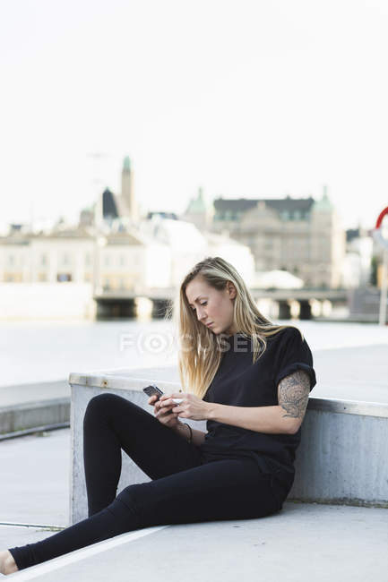Student using mobile phone on steps — Stock Photo