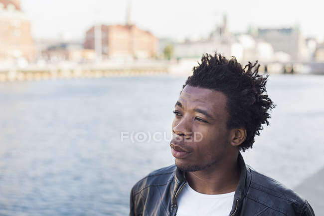 College student looking away by river — Stock Photo