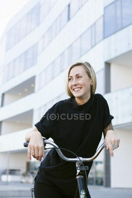 Estudiante con bicicleta contra edificio - foto de stock
