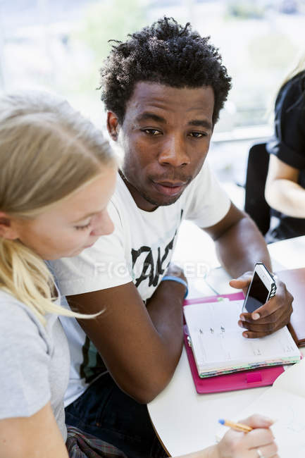 Estudiante mirando hacia otro lado mientras estudia - foto de stock