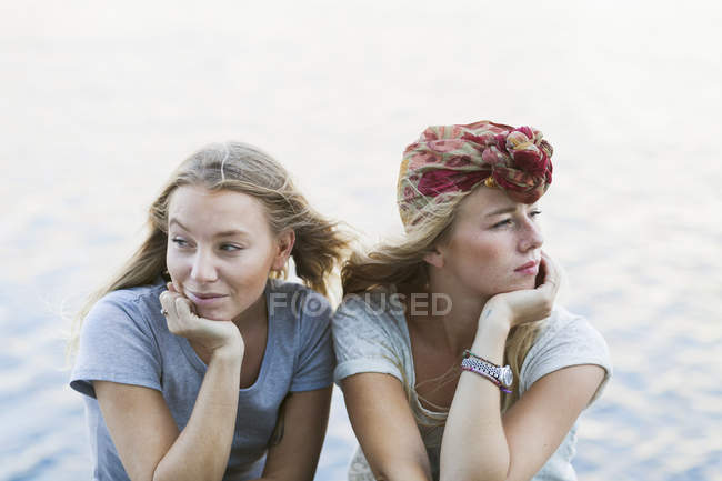 Female friends with hands on chins — Stock Photo