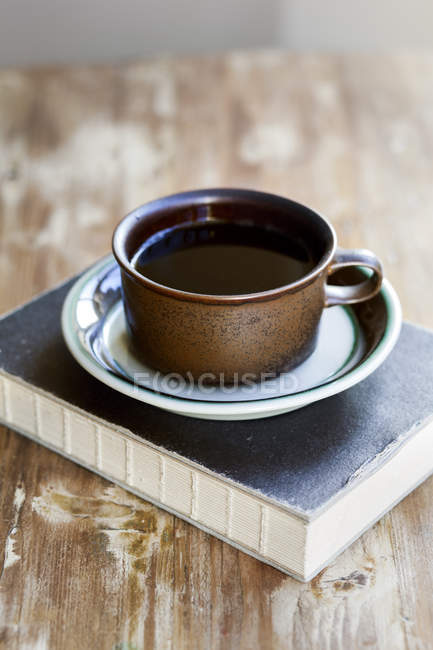 Café negro y libro - foto de stock
