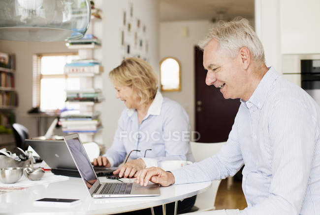 Couple using laptops — Stock Photo