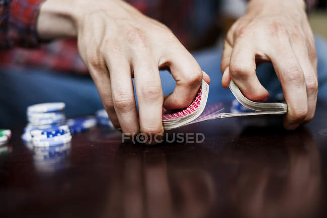 Manos de hombre barajando baraja de cartas - foto de stock
