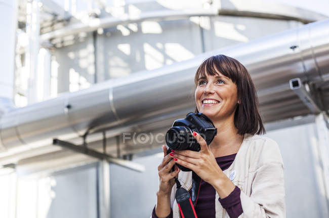 Mujer sosteniendo cámara digital - foto de stock