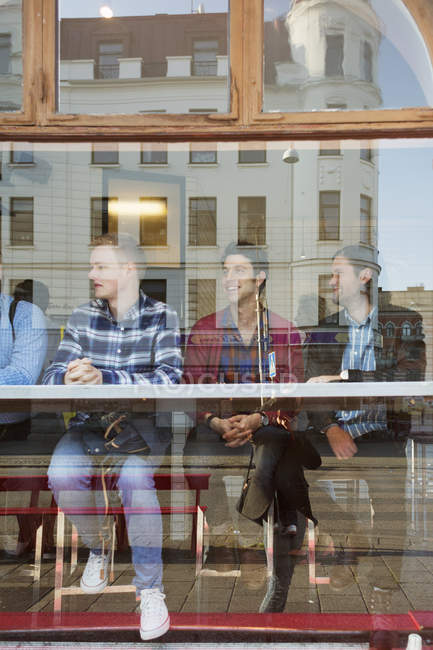 Male friends sitting in cafe — Stock Photo