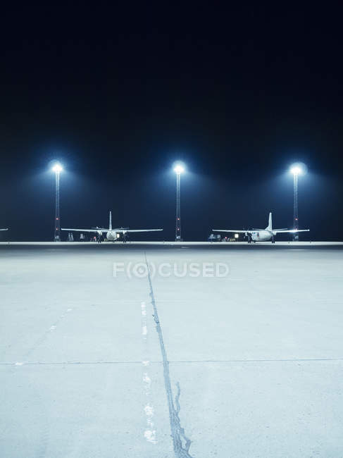 Projecteurs éclairés devant les avions — Photo de stock