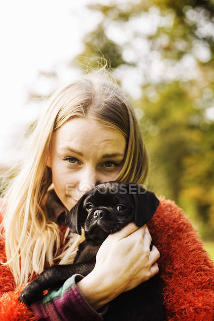 Giovane donna abbracciando cucciolo — Foto stock