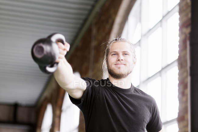 Young man exercising with kittlebell — Stock Photo