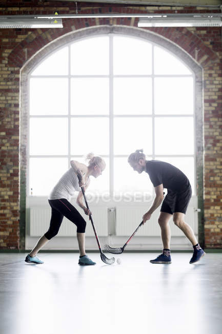 Hombre y mujer jugando hockey - foto de stock