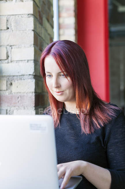 Jeune femme utilisant un ordinateur portable — Photo de stock
