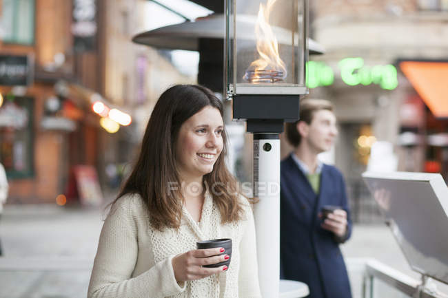 Mujer con taza de café y teléfono móvil - foto de stock