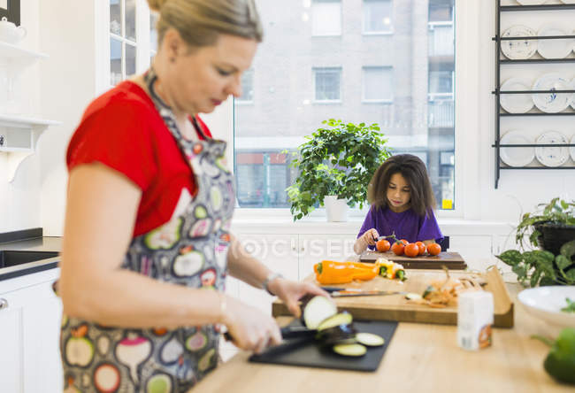 Mãe e filha cortando legumes — Fotografia de Stock