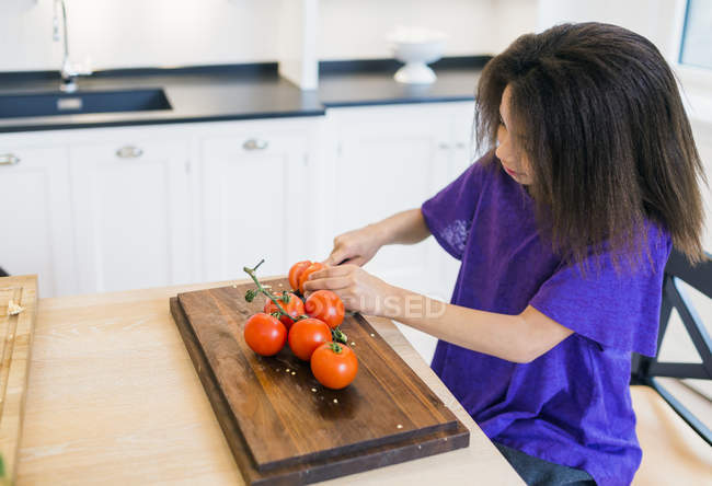 Девушка режет помидоры — стоковое фото
