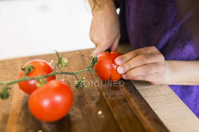 Дівчина нарізки помідори — стокове фото