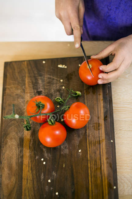 Дівчина нарізки помідори — стокове фото