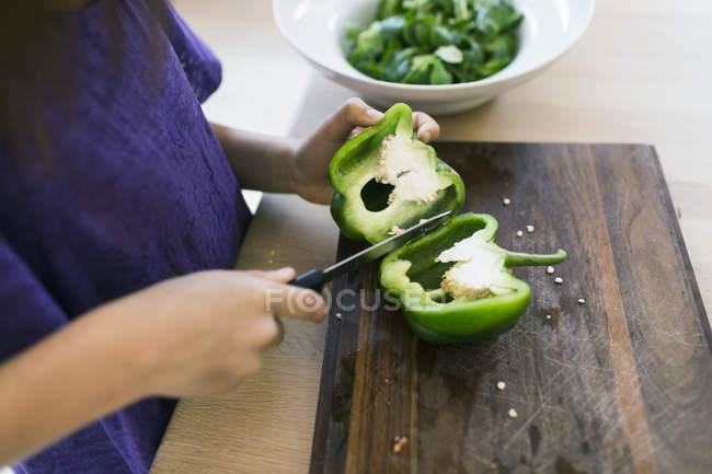 Girl slicing bell pepper — Stock Photo