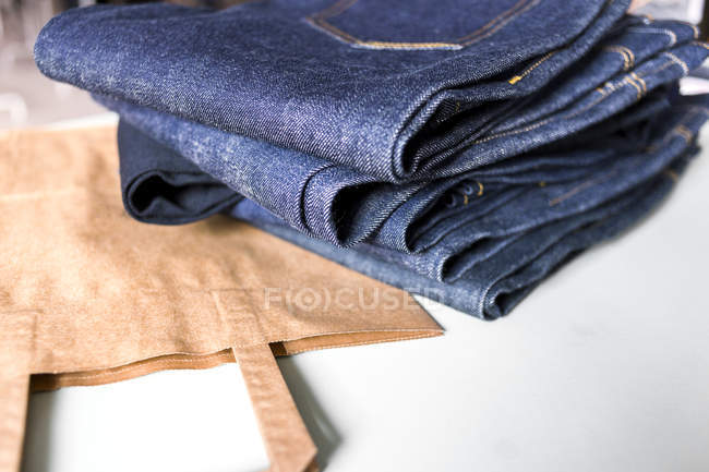 New jeans and bag on table — Stock Photo