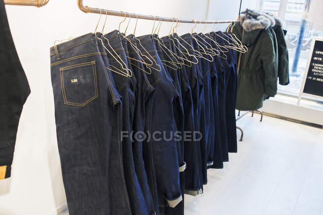 Jeans pendurados no rack — Fotografia de Stock