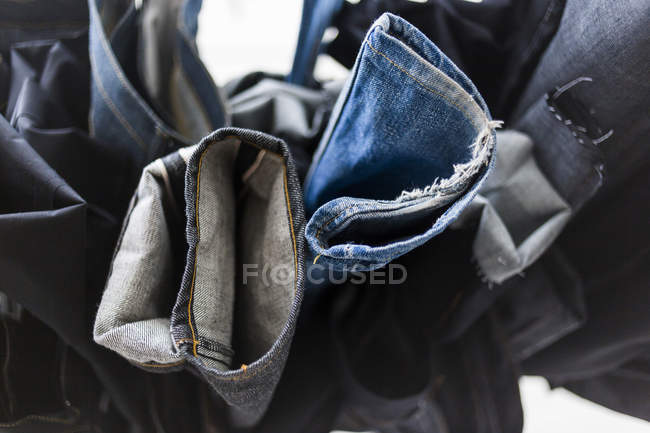 Pièces de jeans suspendues dans l'usine — Photo de stock