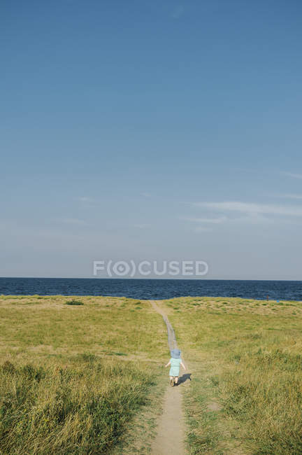 Menina correndo para o lago — Fotografia de Stock