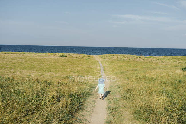 Chica corriendo hacia el lago - foto de stock