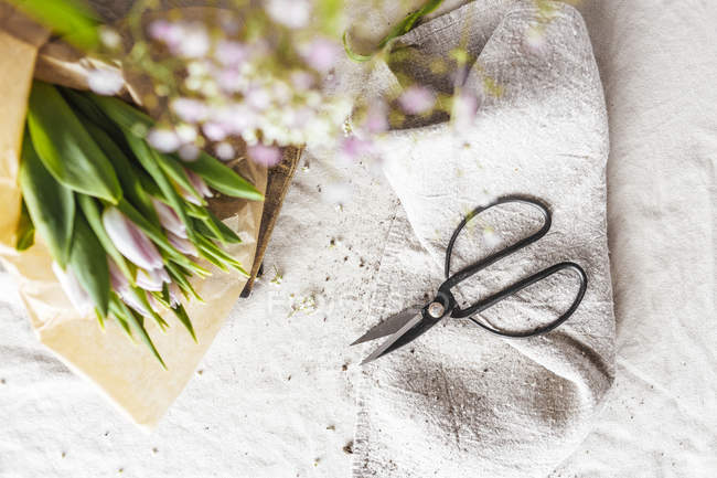 Flowers and scissors on table — Stock Photo