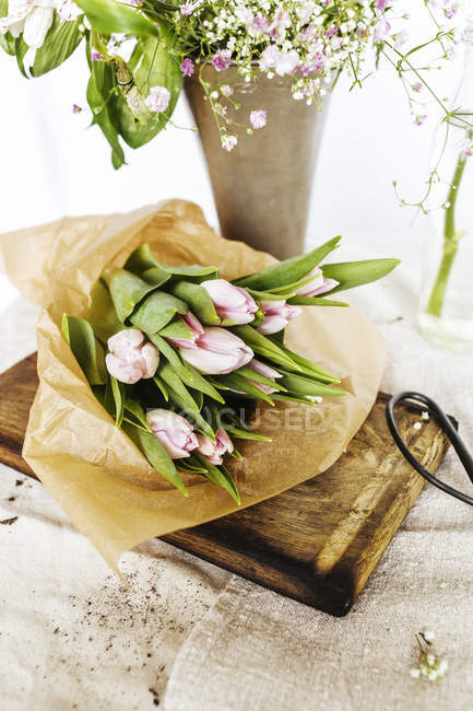 Bouquet de tulipes sur planche à découper — Photo de stock