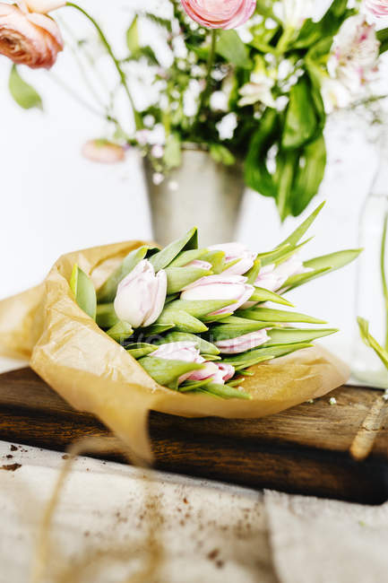 Tulip bouquet on chopping board — Stock Photo
