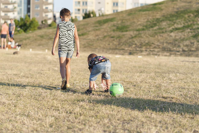 Irmão e irmã no campo gramado — Fotografia de Stock