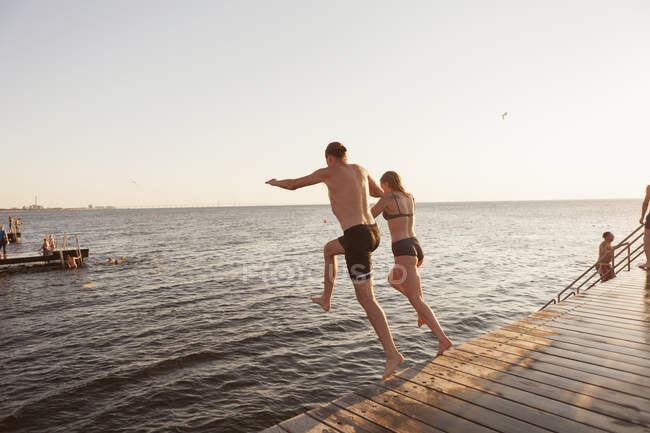 Casal pulando no mar — Fotografia de Stock