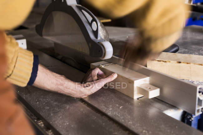 Madeira de corte de carpinteiro usando serra de mesa — Fotografia de Stock