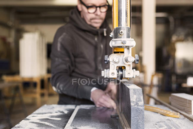 Carpinteiro usando serra de fita para cortar madeira — Fotografia de Stock