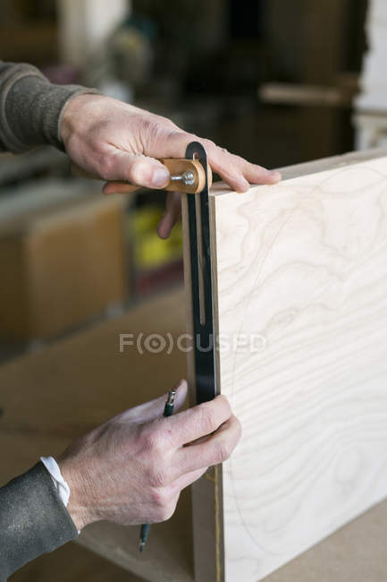 Carpenters hands measuring wood — Stock Photo